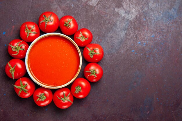 Vista superior deliciosa sopa de tomate con tomates rojos frescos sobre fondo oscuro plato de tomate sopa cena cena