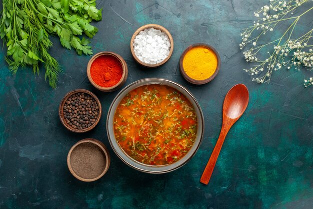 Vista superior deliciosa sopa de verduras con diferentes condimentos en el producto de ingrediente de sopa de verduras de comida de escritorio gris