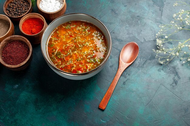 Vista superior deliciosa sopa de verduras con diferentes condimentos en el producto de ingrediente de sopa de verduras de comida de superficie gris