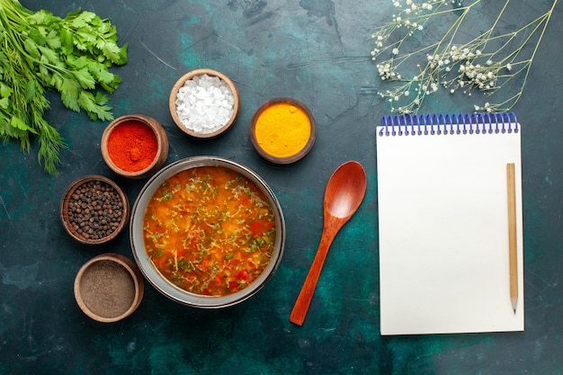 Vista superior deliciosa sopa de verduras con diferentes condimentos en el producto de ingredientes de sopa de verduras de comida de superficie gris