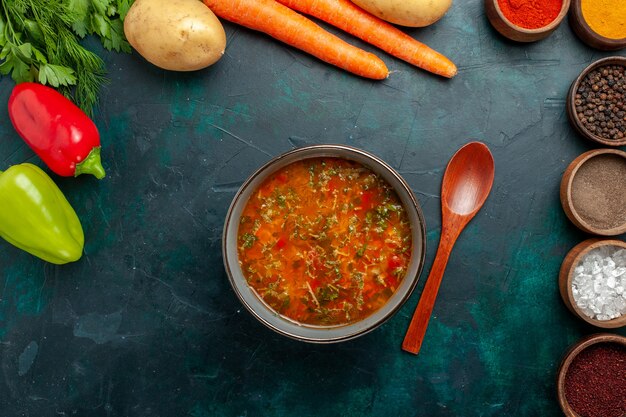 Vista superior deliciosa sopa de verduras con diferentes condimentos en la superficie verde oscuro alimentos vegetales ingredientes sopa producto comida