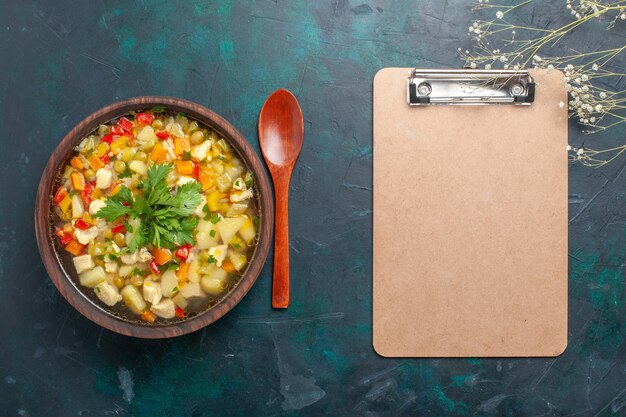 Vista superior deliciosa sopa de verduras con diferentes ingredientes y bloc de notas en el escritorio oscuro sopa de verduras salsa comida comida caliente