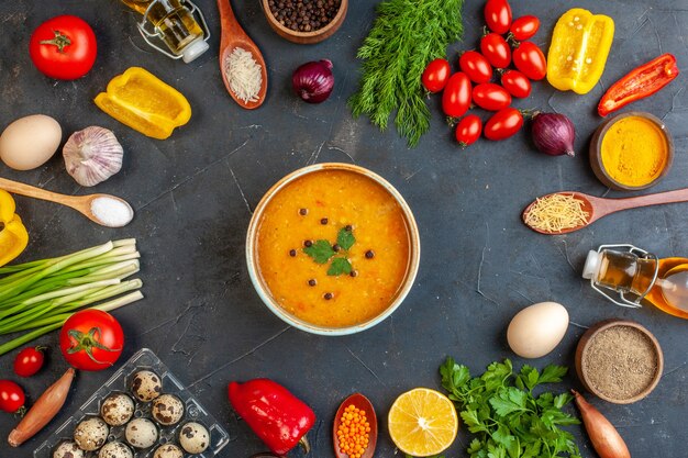 Vista superior de deliciosa sopa y verduras frescas, huevos de paquetes de limón verde en la oscuridad