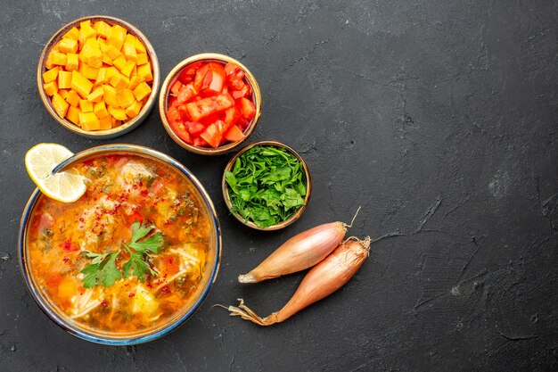 Vista superior deliciosa sopa con verduras y verduras en el espacio gris