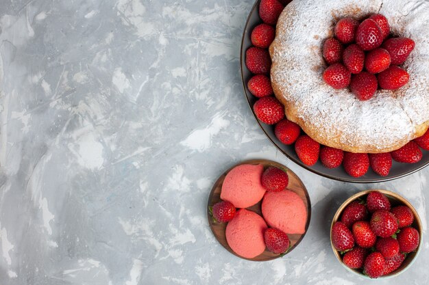 Vista superior deliciosa tarta de fresa con fresas rojas frescas sobre blanco claro