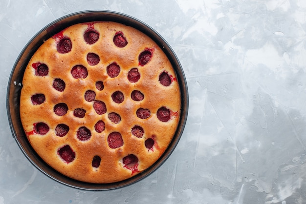 Vista superior de la deliciosa tarta de fresas horneada con fresas rojas frescas en el interior con pan en el escritorio blanco, tarta, galleta, fruta dulce