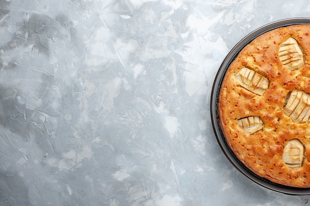 Vista superior de la deliciosa tarta de manzana dulce al horno dentro de la sartén en el escritorio blanco