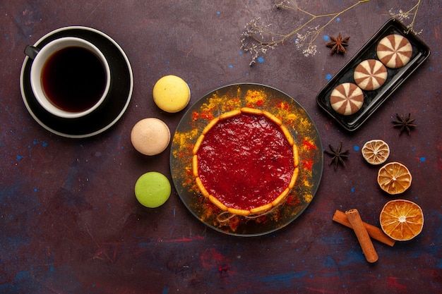 Vista superior de la deliciosa tarta de postre con una taza de macarons de café y galletas de chocolate sobre fondo oscuro, galletas de azúcar, galletas, postre dulce