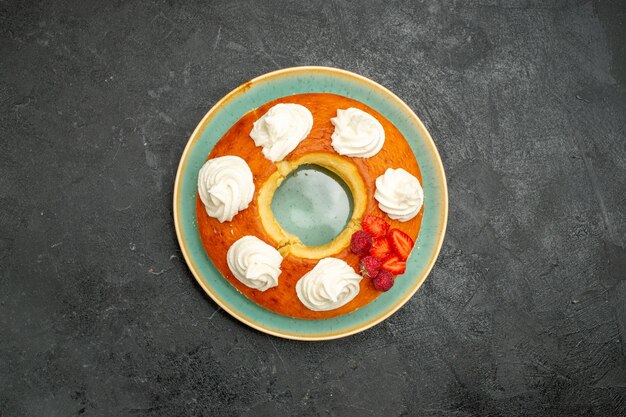 Vista superior deliciosa tarta redonda con frutas y crema sobre el fondo oscuro pastel de galletas de galletas de azúcar de té dulce tarta