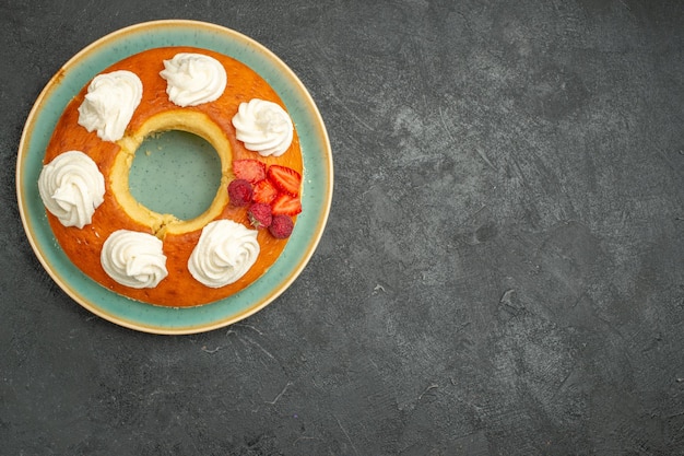 Vista superior deliciosa tarta redonda con frutas y crema sobre el fondo oscuro pastel de galletas de galletas de azúcar de té dulce tarta