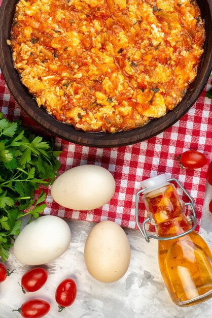 Vista superior deliciosa tortilla con tomates fritos alrededor de verduras frescas sobre fondo blanco desayuno pan almuerzo