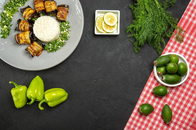 Vista superior deliciosas berenjenas cocidas con arroz feijoa y rodajas de limón en superficie oscura cena comida cocinando arroz