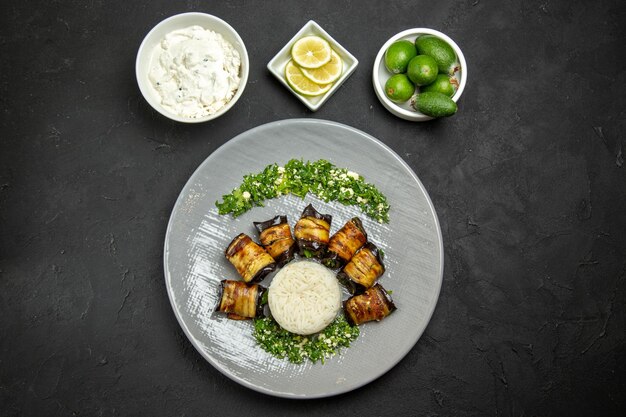 Vista superior deliciosas berenjenas cocidas con arroz limón y feijoa en la superficie oscura cena comida aceite de cocina harina de arroz