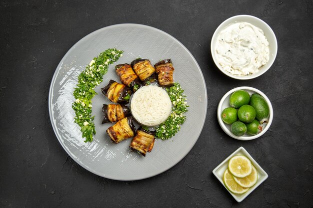 Vista superior deliciosas berenjenas cocidas con arroz limón y feijoa en la superficie oscura cena comida aceite de cocina harina de arroz