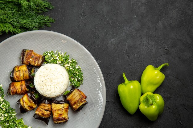 Vista superior deliciosas berenjenas cocidas con arroz en la superficie oscura cena comida aceite de cocina harina de arroz