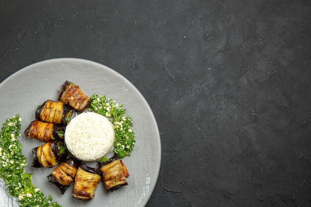 Vista superior deliciosas berenjenas cocidas con verduras y arroz en superficie oscura cena comida aceite de cocina harina de arroz