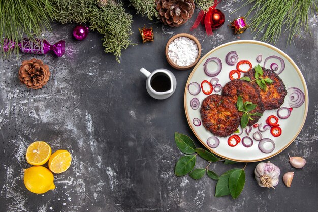 Vista superior deliciosas chuletas con aros de cebolla en el fondo gris plato comida foto carne