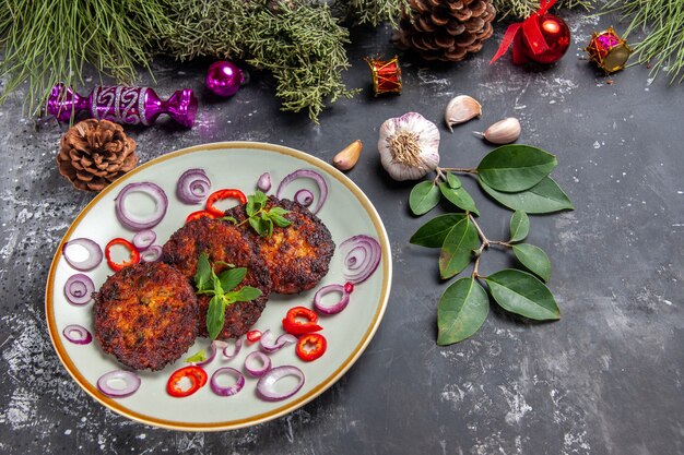 Vista superior deliciosas chuletas con aros de cebolla sobre fondo gris comida foto plato carne