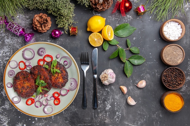 Vista superior deliciosas chuletas con aros de cebolla sobre fondo gris plato cocina de carne