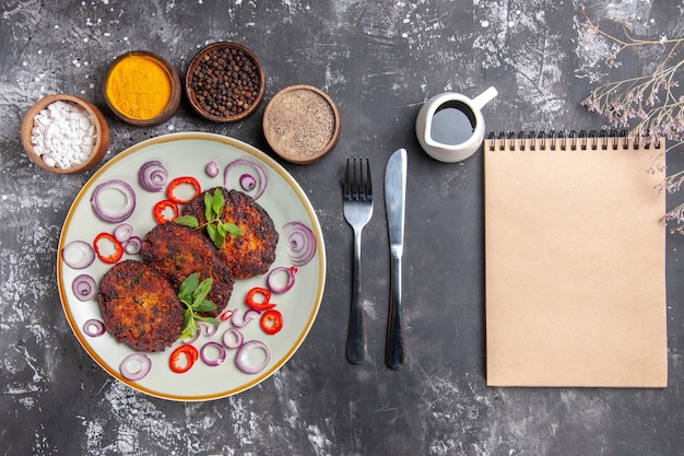 Vista superior deliciosas chuletas con aros de cebolla