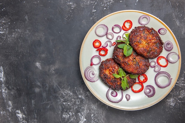 Vista superior deliciosas chuletas de carne con aros de cebolla