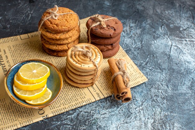 Vista superior de deliciosas galletas apiladas canela limón en un periódico viejo sobre fondo oscuro