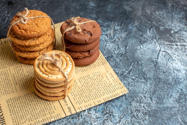 Vista superior de deliciosas galletas apiladas en un periódico viejo sobre fondo oscuro