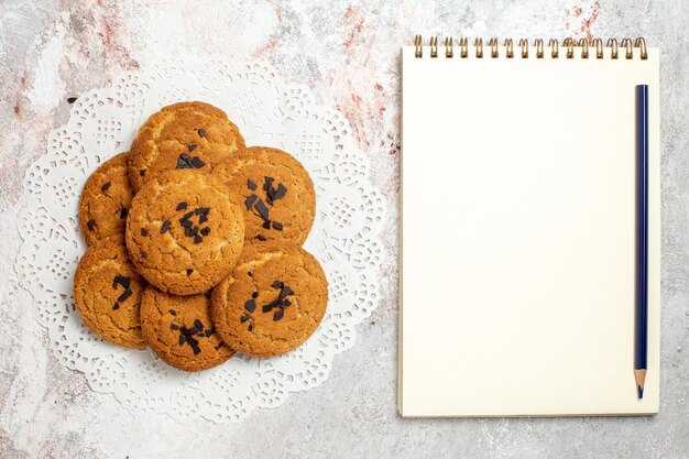 Vista superior de deliciosas galletas de arena dulces perfectos para taza de té en superficie blanca