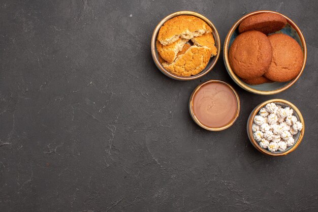 Vista superior deliciosas galletas de azúcar con caramelos sobre fondo oscuro galleta de azúcar galleta dulce