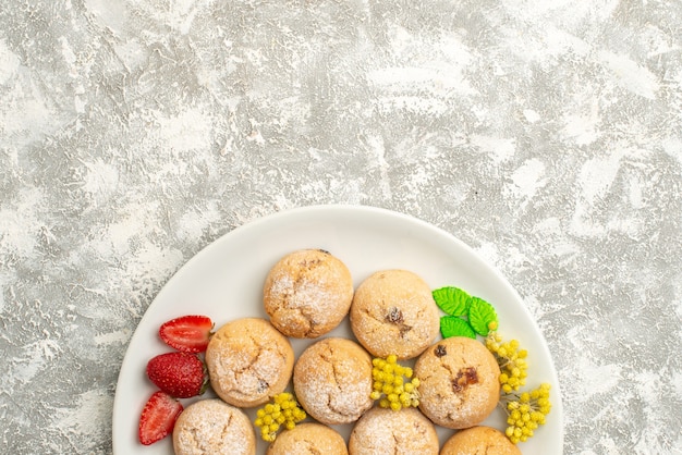 Vista superior deliciosas galletas de azúcar dentro de la placa sobre fondo blanco galletas de azúcar pastel de galletas dulces té