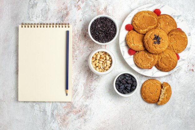 Vista superior de deliciosas galletas de azúcar con nueces sobre superficie blanca