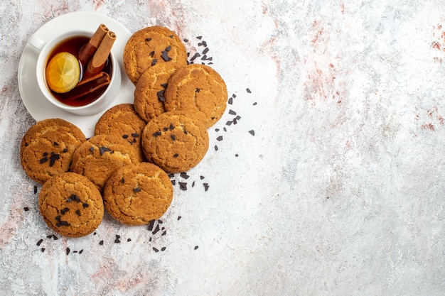 Vista superior de deliciosas galletas de azúcar con té sobre superficie blanca