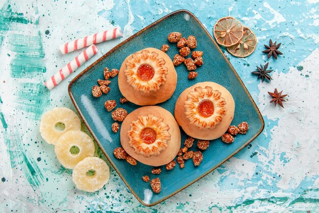 Vista superior deliciosas galletas con caramelos en el color azul claro del azúcar dulce de la galleta de la galleta del escritorio