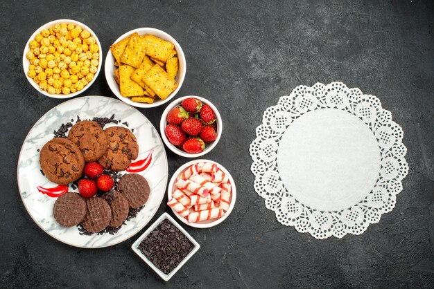 Vista superior deliciosas galletas choco con diferentes bocadillos sobre fondo oscuro galleta té dulce