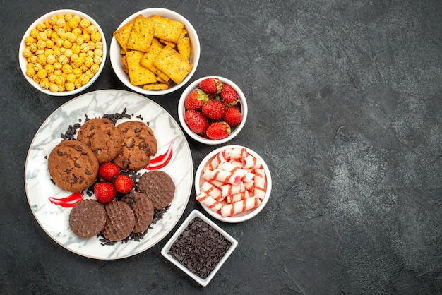 Vista superior deliciosas galletas choco con diferentes bocadillos sobre fondo oscuro té dulce galleta