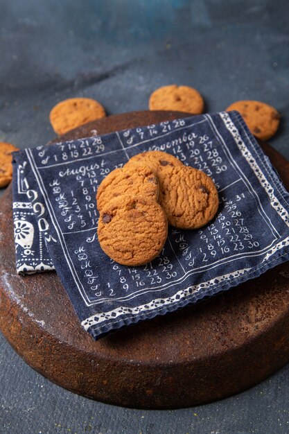 Vista superior deliciosas galletas de chocolate horneadas y deliciosas en el fondo gris oscuro galleta galleta té dulce