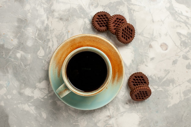 Vista superior deliciosas galletas de chocolate con taza de café sobre fondo blanco pastel de pastel dulce de azúcar de galleta de té