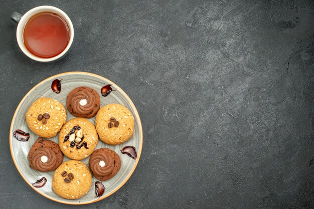 Vista superior deliciosas galletas dulces deliciosos dulces para té en el espacio gris