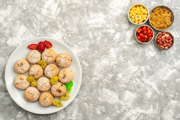 Vista superior deliciosas galletas dulces con pasas sobre fondo blanco galleta de caramelo galleta té dulce azúcar