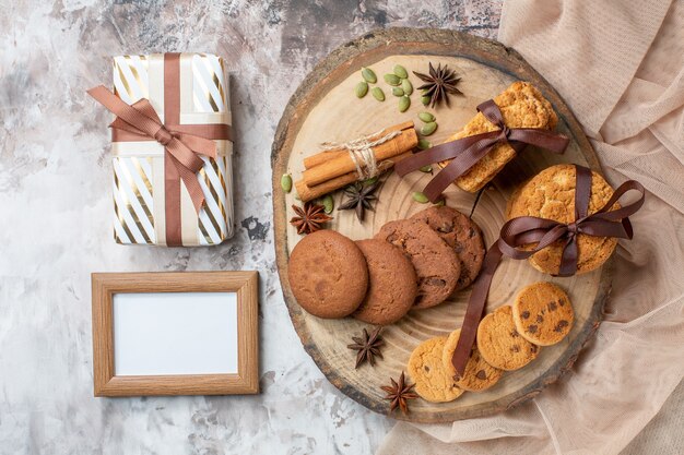 Vista superior deliciosas galletas dulces con presente en mesa de luz