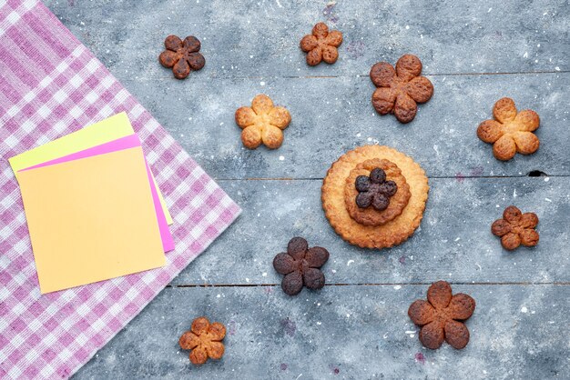 Vista superior de deliciosas galletas dulces repartidas por todo el gris de madera, galleta de galleta dulce