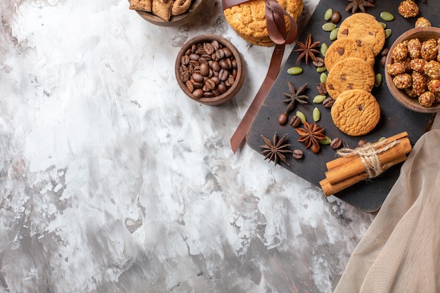Vista superior deliciosas galletas dulces con semillas de café y una taza de café en la mesa de luz