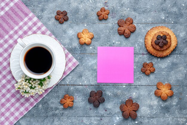 Vista superior de deliciosas galletas dulces con taza de café el escritorio rústico gris, galleta de azúcar galleta dulce