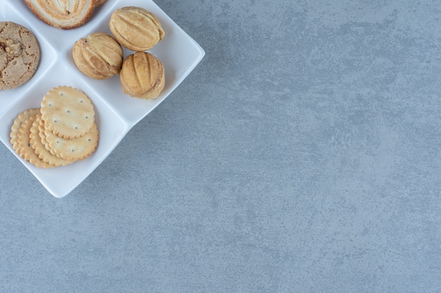 Vista superior de deliciosas galletas frescas en un plato blanco.