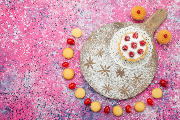 Vista superior deliciosas galletas con frutos rojos y pastel en el dulce de azúcar de galleta de escritorio brillante