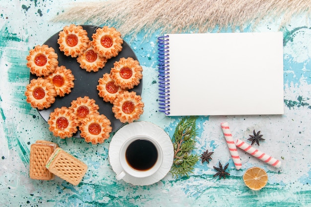 Foto gratuita vista superior deliciosas galletas con gofres y taza de café en el escritorio azul galleta galleta dulce azúcar color té