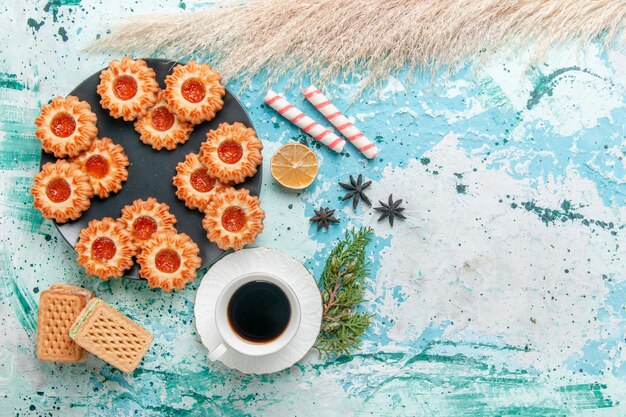 Vista superior deliciosas galletas con gofres y una taza de café en el escritorio azul galleta galleta dulce color azúcar