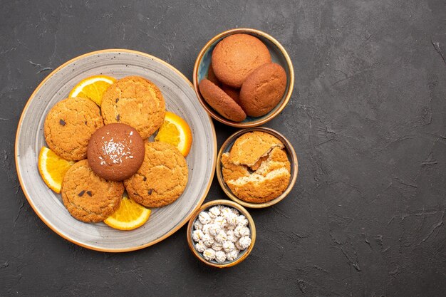 Vista superior deliciosas galletas con naranjas frescas en rodajas sobre fondo oscuro galleta galleta fruta cítricos dulces