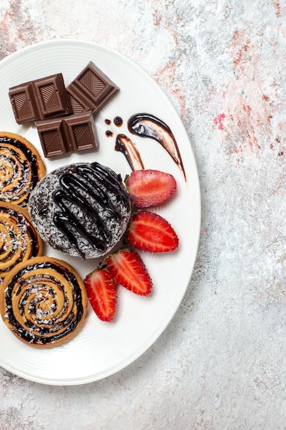 Foto gratuita vista superior deliciosas galletas con pastel de chocolate y fresas en un espacio en blanco claro