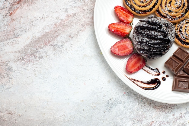 Foto gratuita vista superior deliciosas galletas con pastel de chocolate y fresas en el espacio en blanco